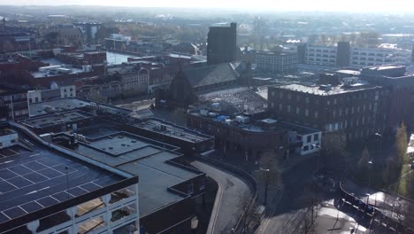 Overhead-aerial-view-above-city-multi-storey-car-park-quiet-British-urban-public-streets-at-sunrise-left-dolly