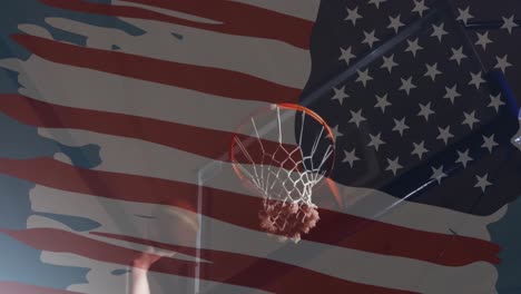 animation of flag of america over hand of caucasian male basketball player taking a shot