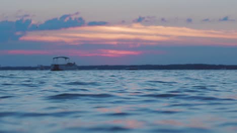 Bunter-Sonnenuntergang-Am-See-Mit-Booten-Und-Vögeln-Am-Horizont