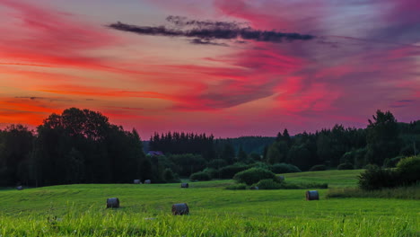increíble y colorido amanecer sobre campos de cultivo con rollos de heno recién embalados - espectacular paisaje nublado de lapso de tiempo