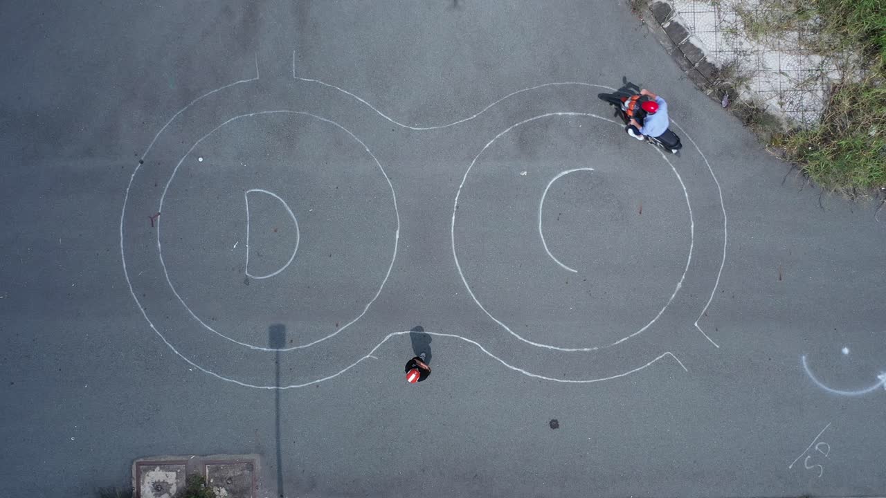 오토바이 라이더는 위에서 아래로 드론 보기에서 테스트 트랙에서 숫자 8을 연습합니다.