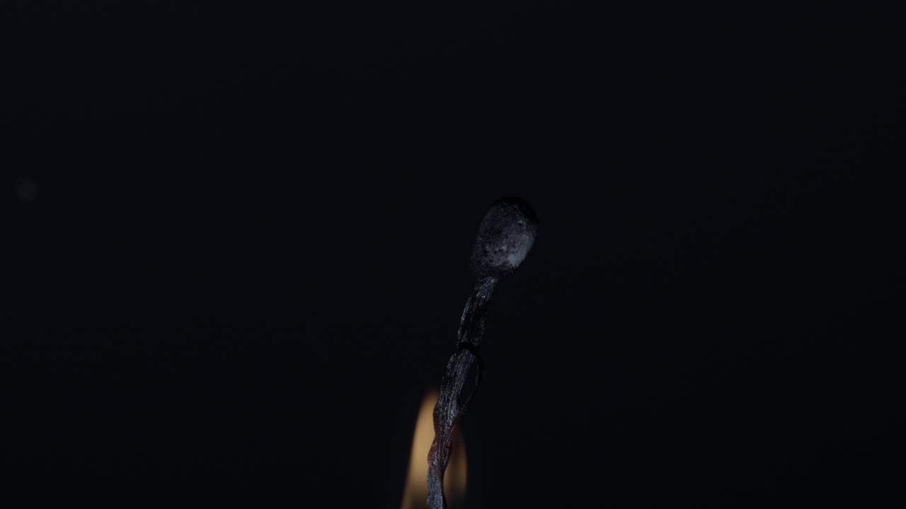 Burning a matchstick in black background - close up