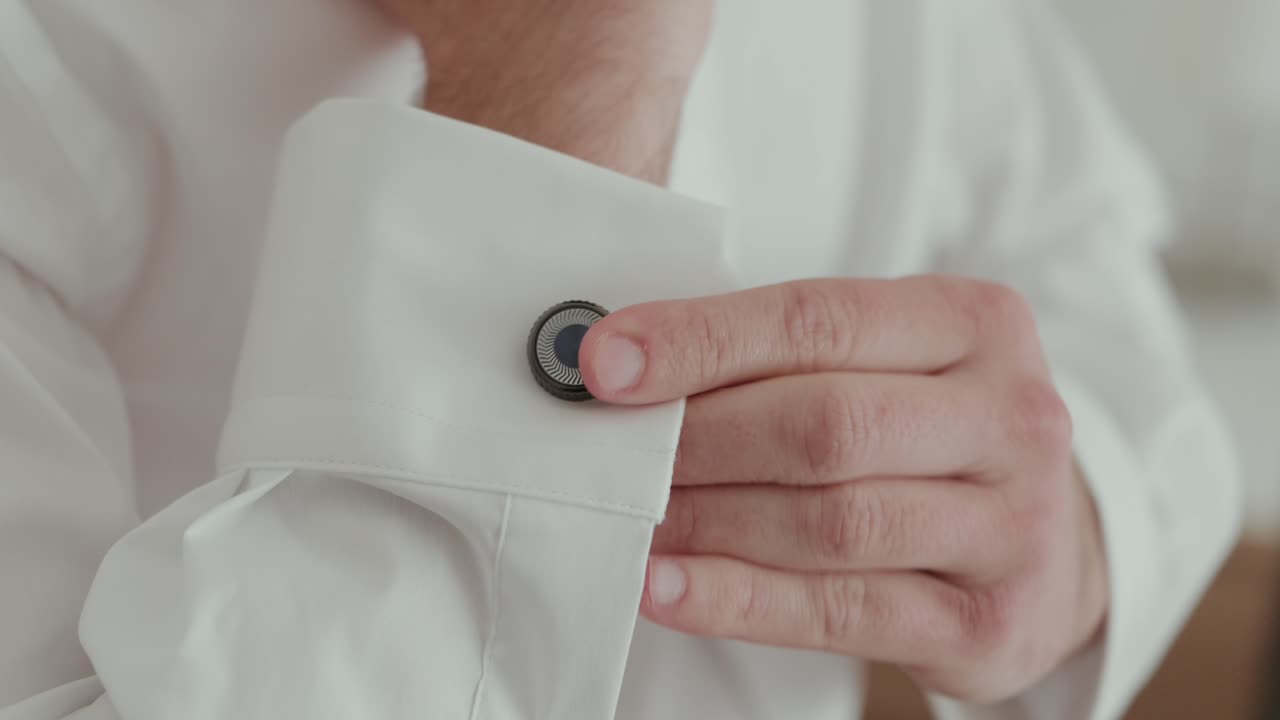 Stylish man fastens cufflink with elegant precision