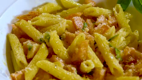 beautiful bowl of penne pasta with tomato sauce with basil and parmesan cheese on a lazy susan, rotating plate