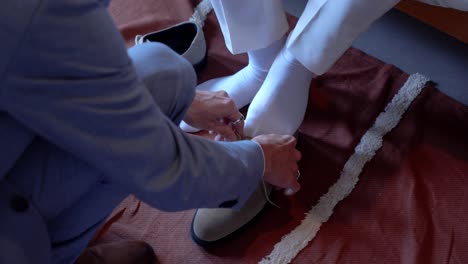 slow motion shot of a groom getting ready and putting on his shoes for the ceremony