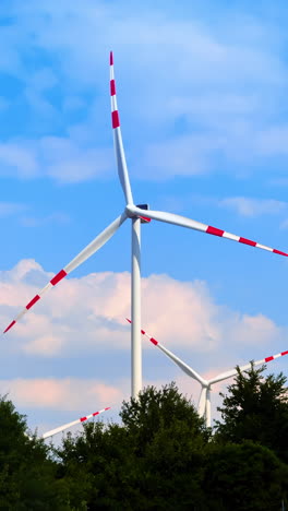 Wind turbines generating clean energy. Wind turbines stand tall against a blue sky, generating renewable energy in a lush, green landscape