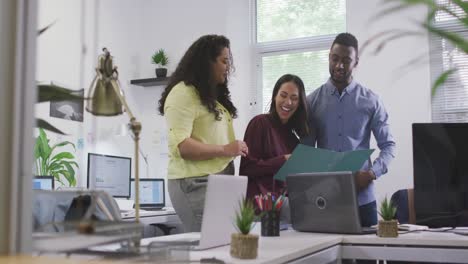 Happy-diverse-group-of-business-people-working-together,-discussing-work-in-modern-office