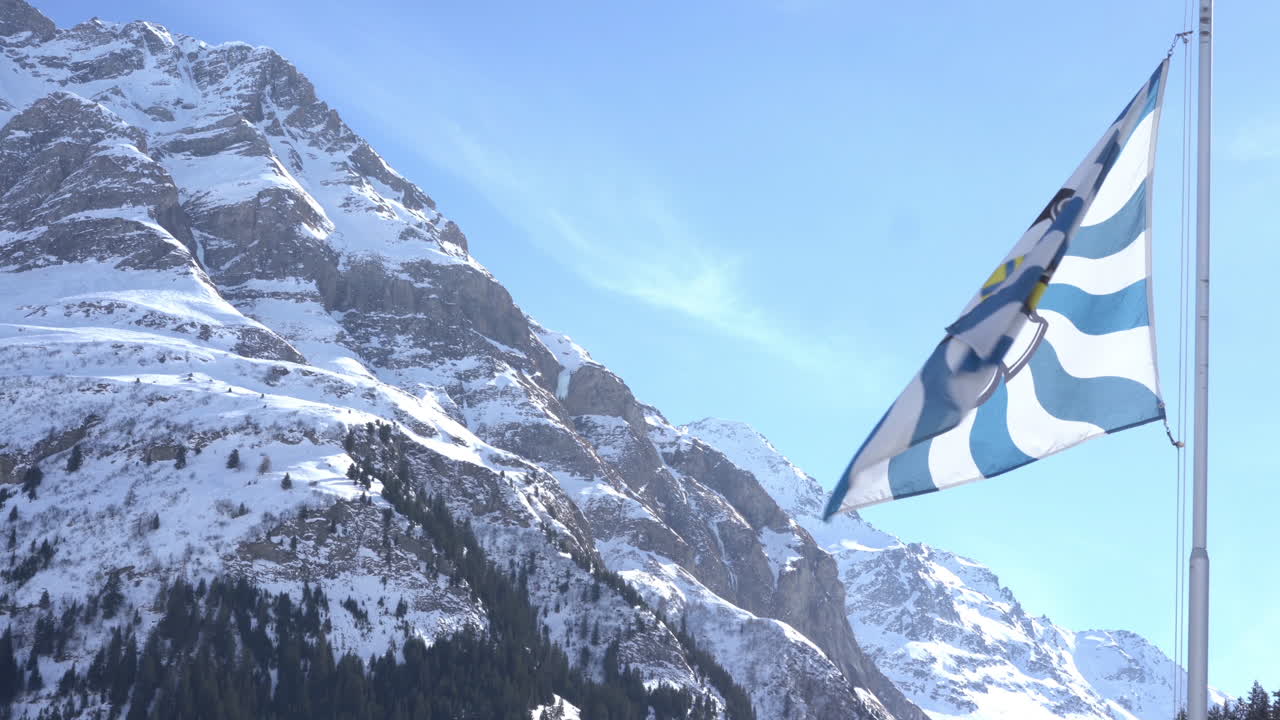 cantón de los grisones suizos bandera ondeando fondo montañas nevadas 4k material de archivo