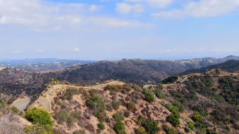 mountains with power lines, roads, and distant city