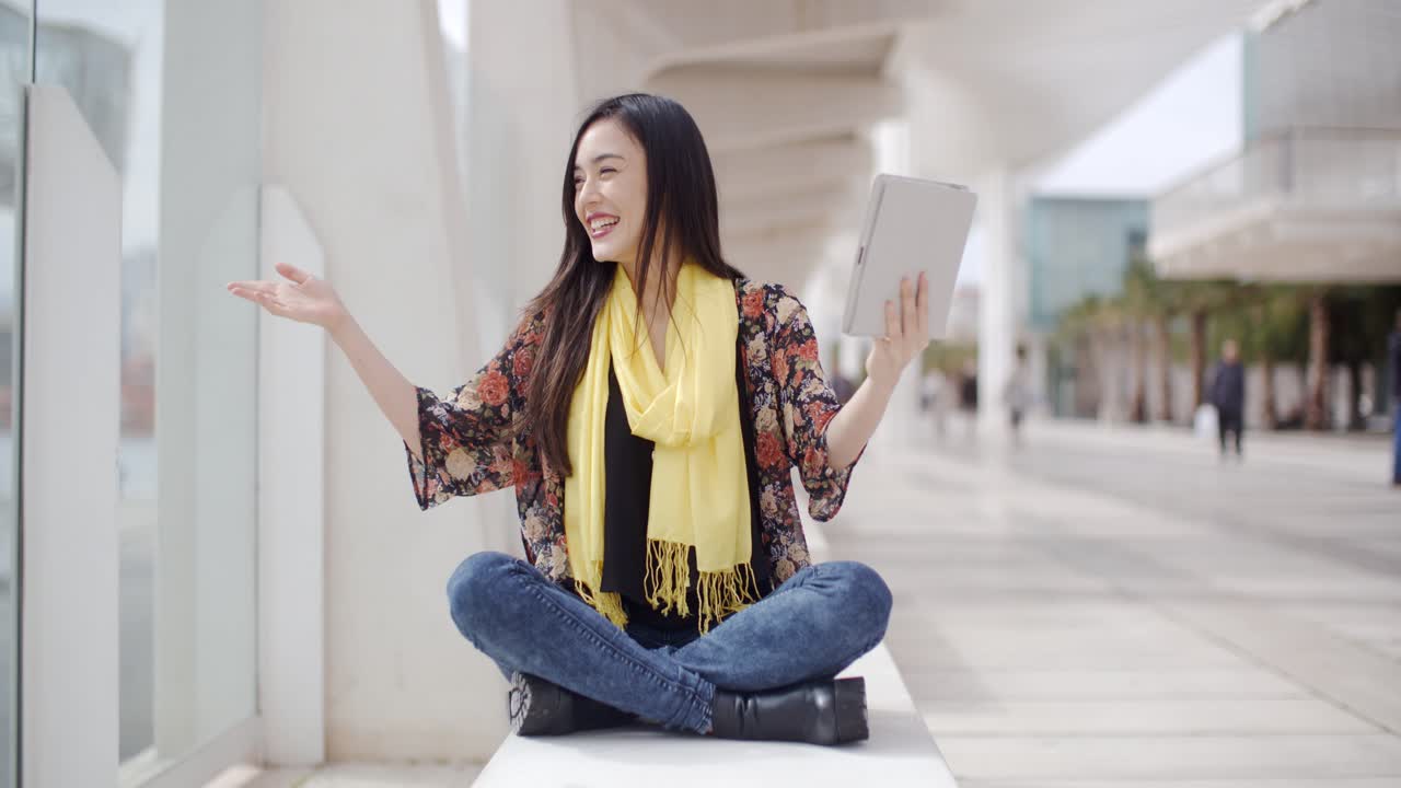 Donna sorridente che saluta il suo tablet