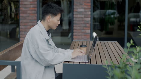 young person working on a laptop outdoors