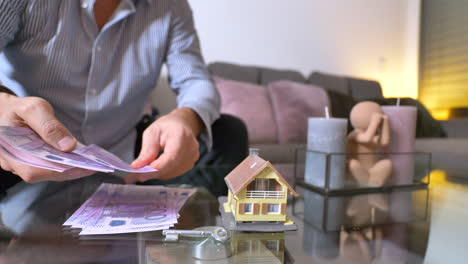 close up of businessman counting five hundred euro banknotes on table for real estate house - caucasian person sitting in living room and counting money - prores 4k