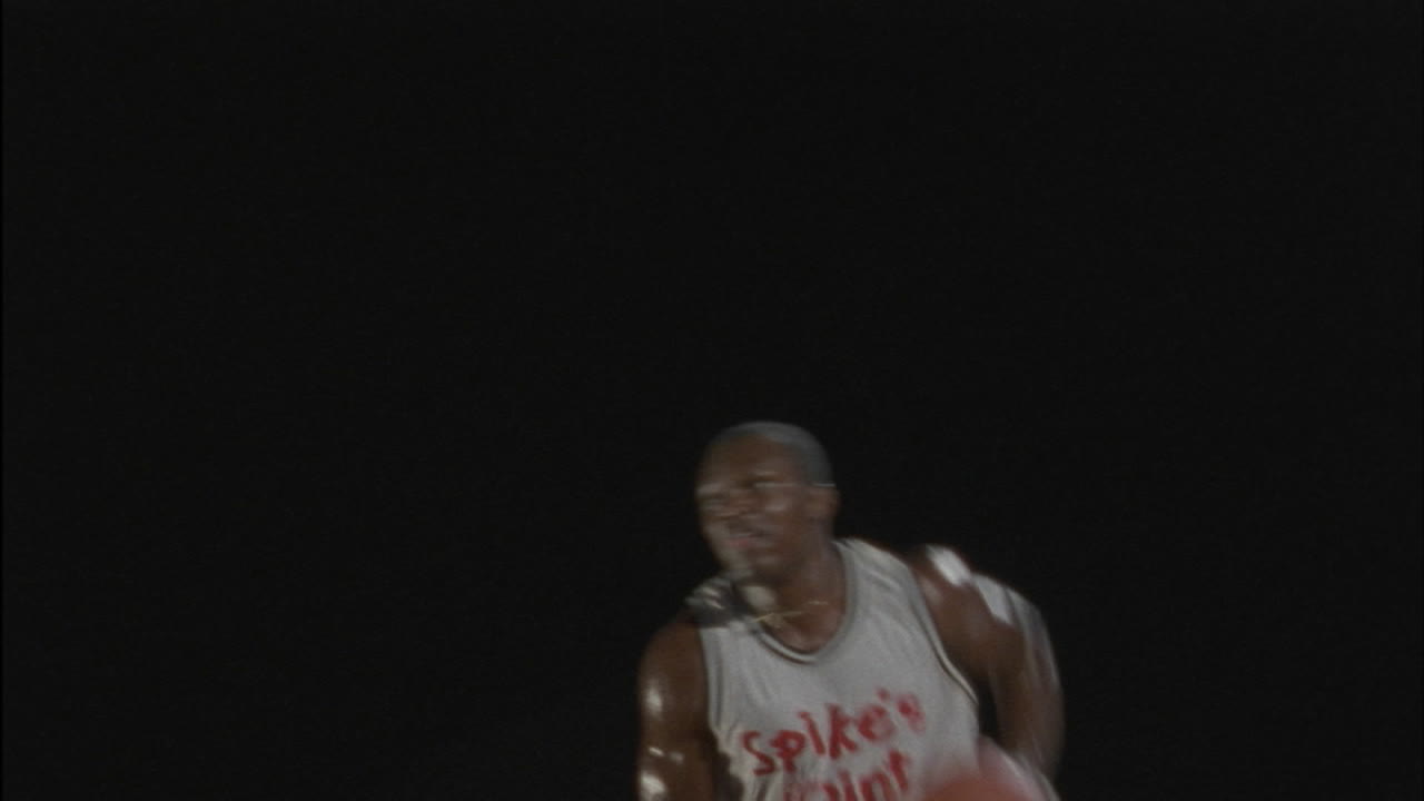 un hombre lanza una pelota de baloncesto al aro y la atrapa cuando rebota