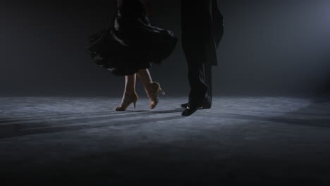 dancers legs doing movements on floor. dance couple feet dancing indoors.