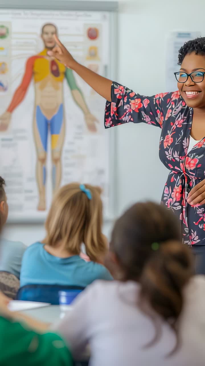 Vertical video: Teacher in blouse raising finger, pointing at anatomy chart in class, for lesson