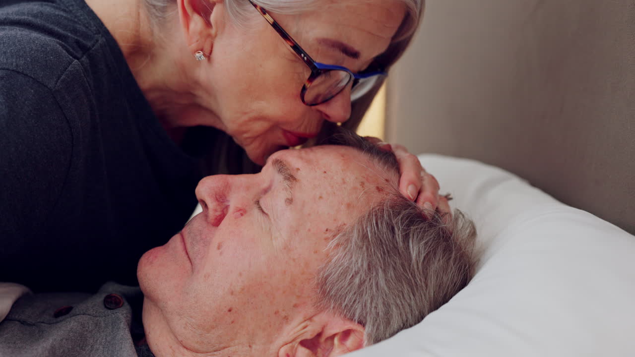Love, old man and woman kiss face in bed