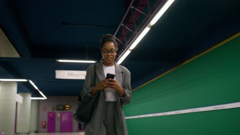 mujer usando el teléfono en una estación de metro