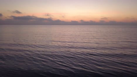 drone flight over calm water, sunrise