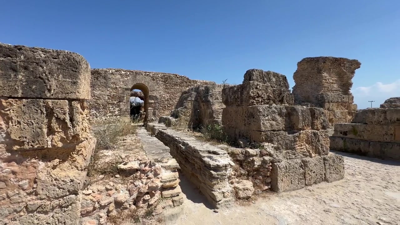 Parlak öğle ışığı altında antik Kartaca kalıntılarının aşınmış taş duvarları. Tunus.