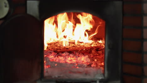 a masonry wood-fired oven during the firing (heating) stage before baking bread in the bakery. - close up shot