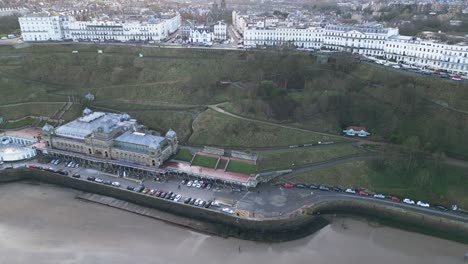 parallax toma cinematográfica del spa de scarborough con filas de apartamentos blancos antiguos en el fondo en la bahía de scarborough, inglaterra