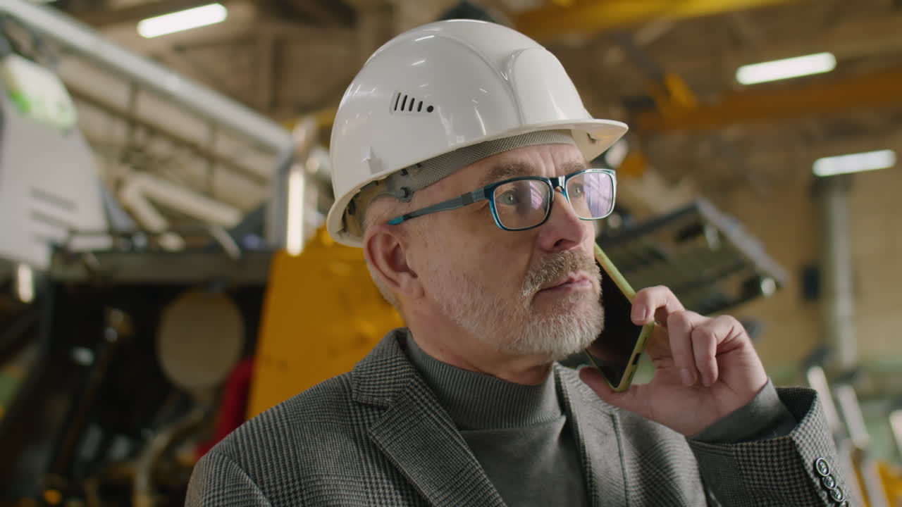 Mature Engineer Talking on Cell Phone in Factory
