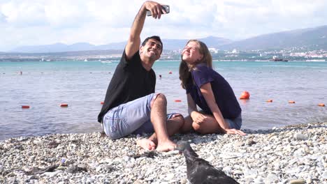 una pareja tomando una selfie en una playa.