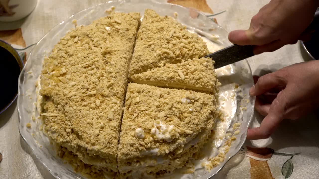 한 여성이 휴가 중 큰 칼로  케이크를 조각으로 잘라내고 있습니다.