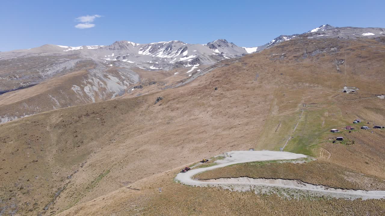 화창한 봄날 폭스 피크 스키장 위로 우뚝 솟은 산의 공중 슬라이딩 전망, 정상에 소량의 눈만 남아 있음