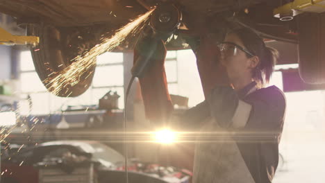 animation of glowing light over caucasian female car mechanic working in workshop