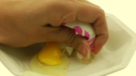 A-woman's-hand-picks-up-and-crushes-an-egg-in-a-bowl-with-the-word-Love-written-on-it