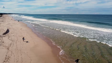 toma aérea de drones de surfistas y personas esperando en la playa de arena romper tabla de surf olas del océano pacífico cristalino viajes turismo la entrada costa central nsw australia 4k