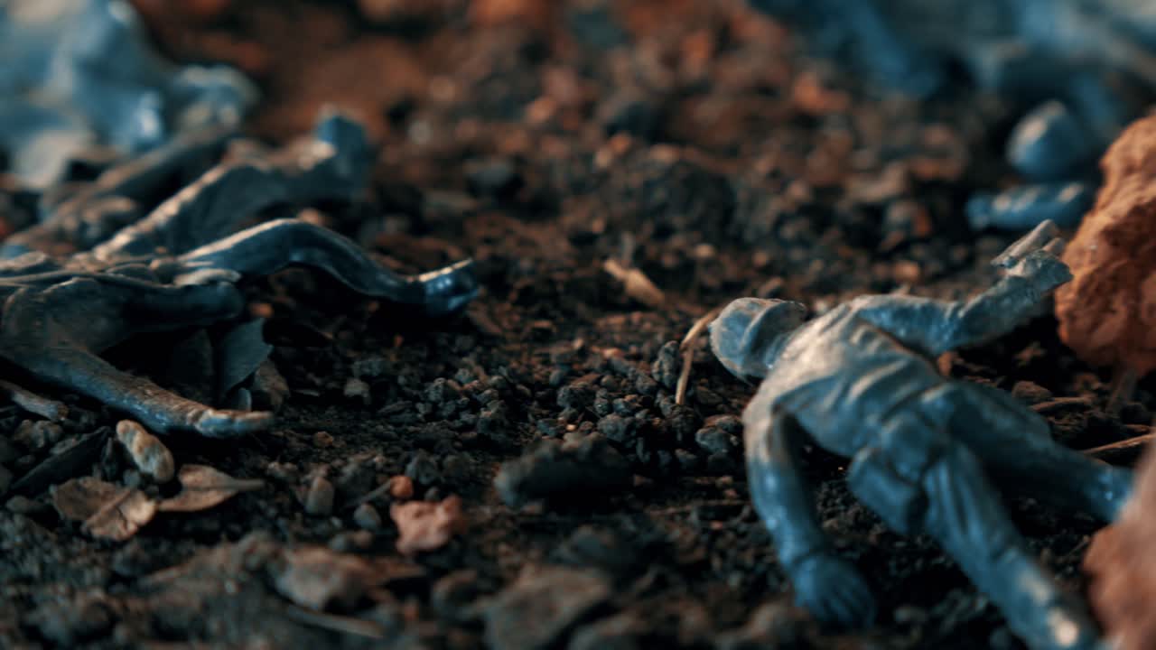 Miniature plastic toy soldier melting on a simulated battlefield. Symbolic concept of war, conflict, destruction, and loss