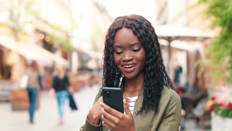 african american woman making a video call with smartphone in the street