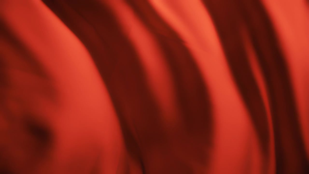 Tessuto rosso setoso che ondeggia al vento. Sfondo con texture astratta