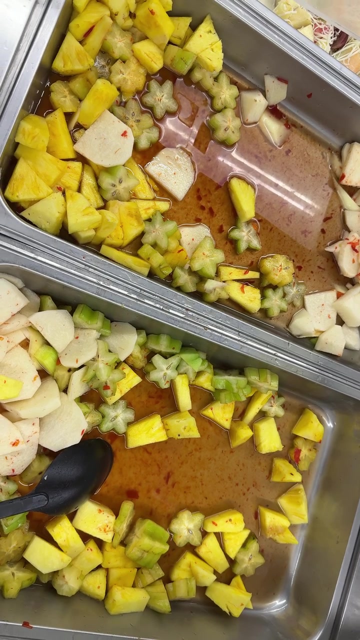 Macedonia di frutta tropicale fresca con ananas, carambola e jicama in vassoi da buffet
