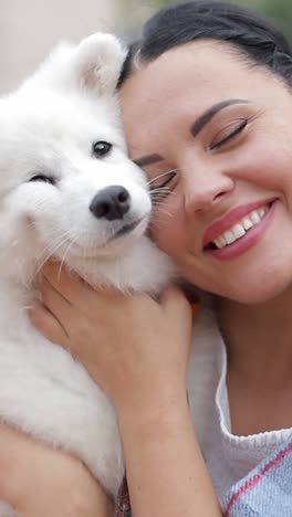 A Joyful Woman Embraces and Cuddles a Fluffy Samoyed Puppy Beautifully Showcasing their Mutual Love a Joyful Woman Embraces and Cuddles a Fluffy Samoyed Puppy Beautifully Showcasing their Mutual Love and Warmth