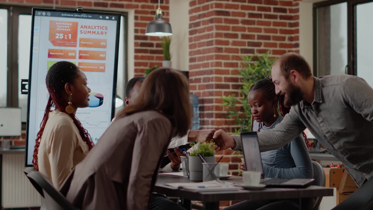 African american man greeting team of coworkers in startup office