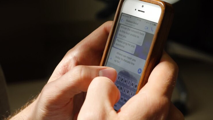 persona che utilizza uno smartphone per inviare un messaggio di testo