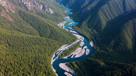 aerial view of a winding river through a forested mountain valley