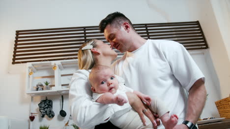 happy young family of three in their home. new-made parents with a baby from low angle perspective.