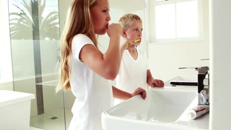 hermanos lavándose los dientes juntos