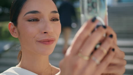 chic model posing holding smartphone at street close up. woman making selfie.