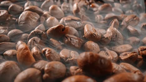 cerca de las semillas de café. los granos de café perfumados son tostados el humo viene de los granos de café.