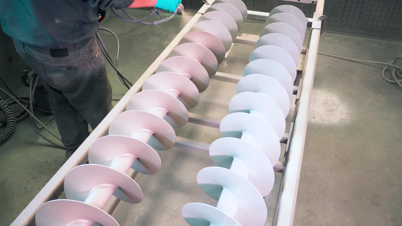 공장에서 스트레이 건이 있는 두 개의 금속 산업용 로터에 흰색 부식 방지 분말 코팅 적용