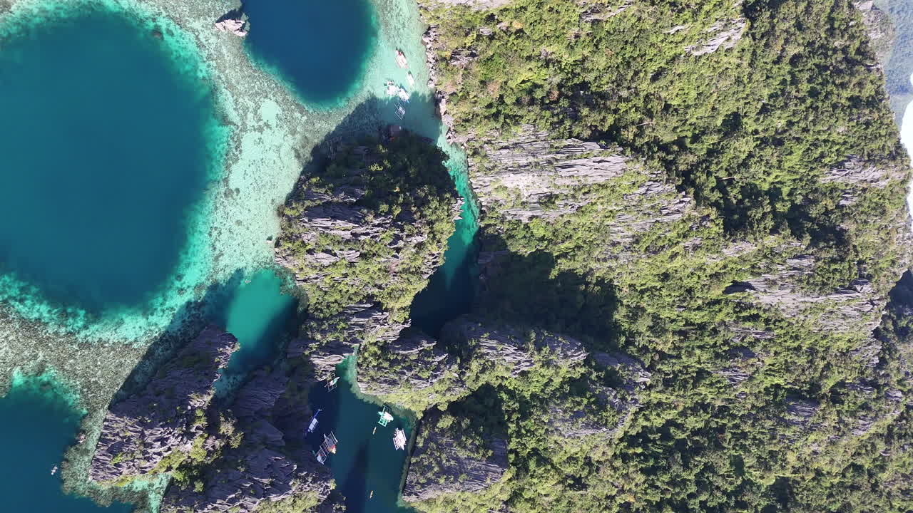 Drone view of Philippines, Coron Island’s untouched coastline, surrounded by lush forests and clear waters. Aerial view of bungalows and lagoon. Vertical video.