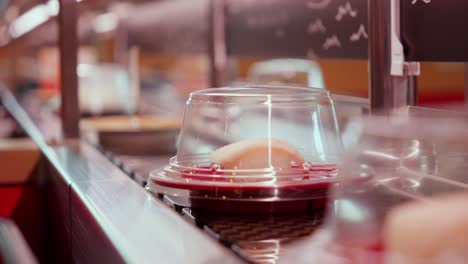 conveyor belt sushi close-up with covered dishes in a restaurant