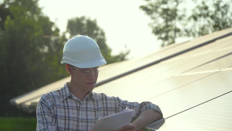 engineer in a white helmet is at the solar power station. green energy concept