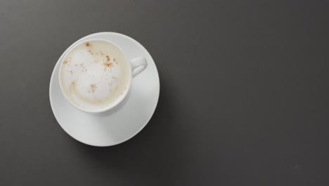 video de una taza blanca de café con leche sobre fondo negro