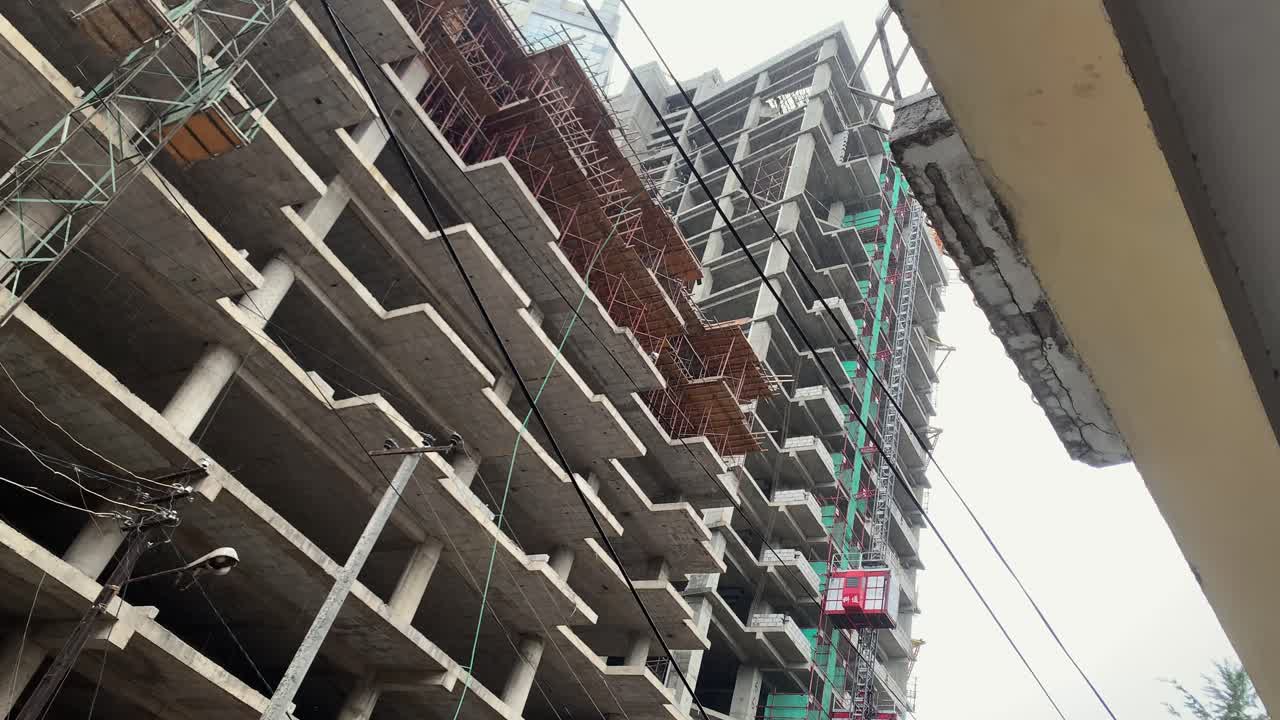 New building under construction with red lift moving upward